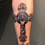 svart och grå tatuering på ett kors